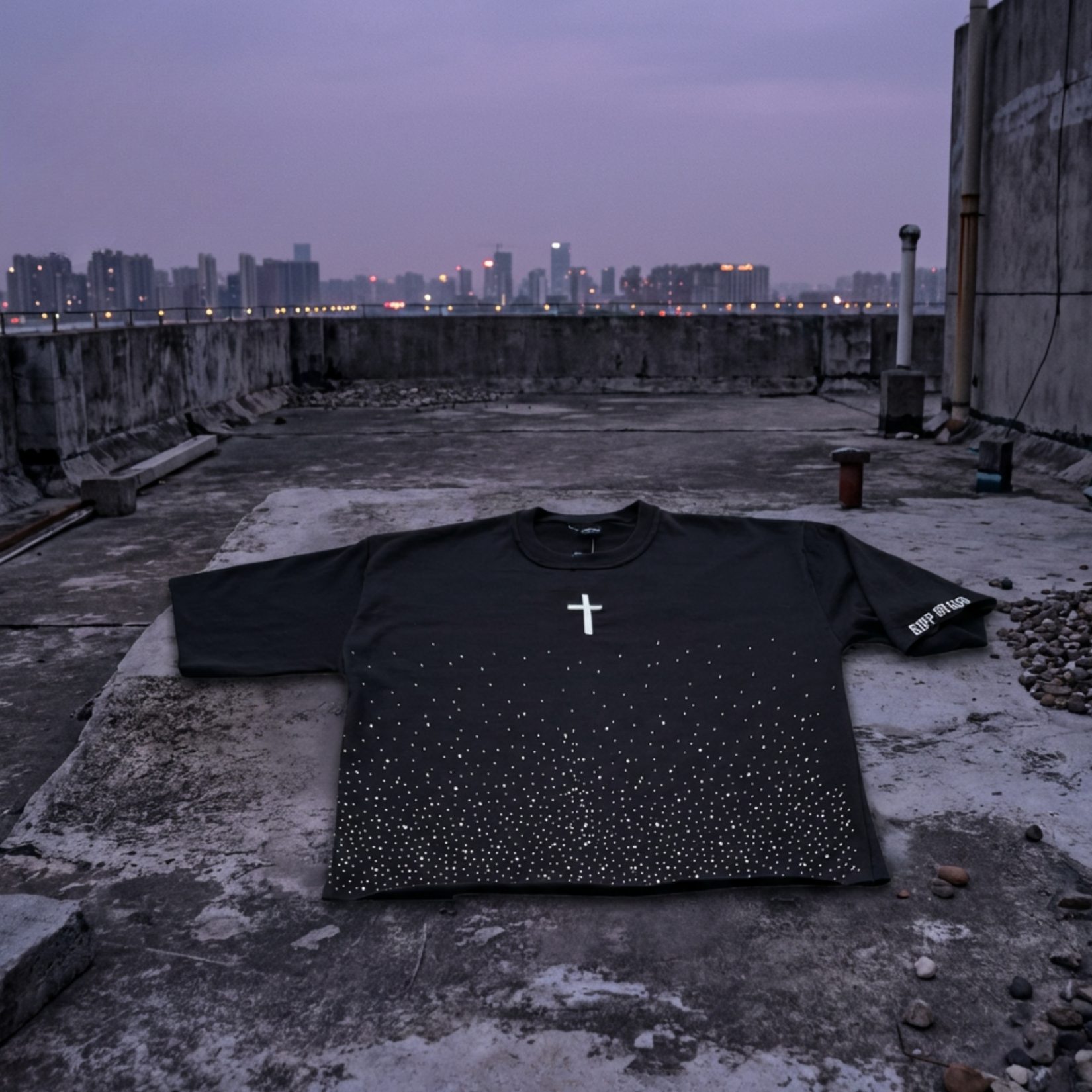 Black long-sleeve shirt with a white cross on a rooftop at dusk